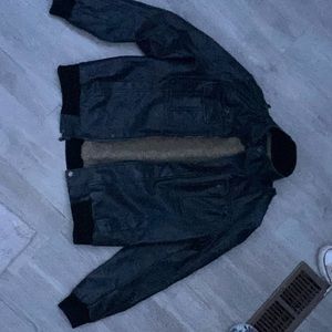 It’s a Calvin Klein leather jacket. It’s mostly made of polyester and acrylic.